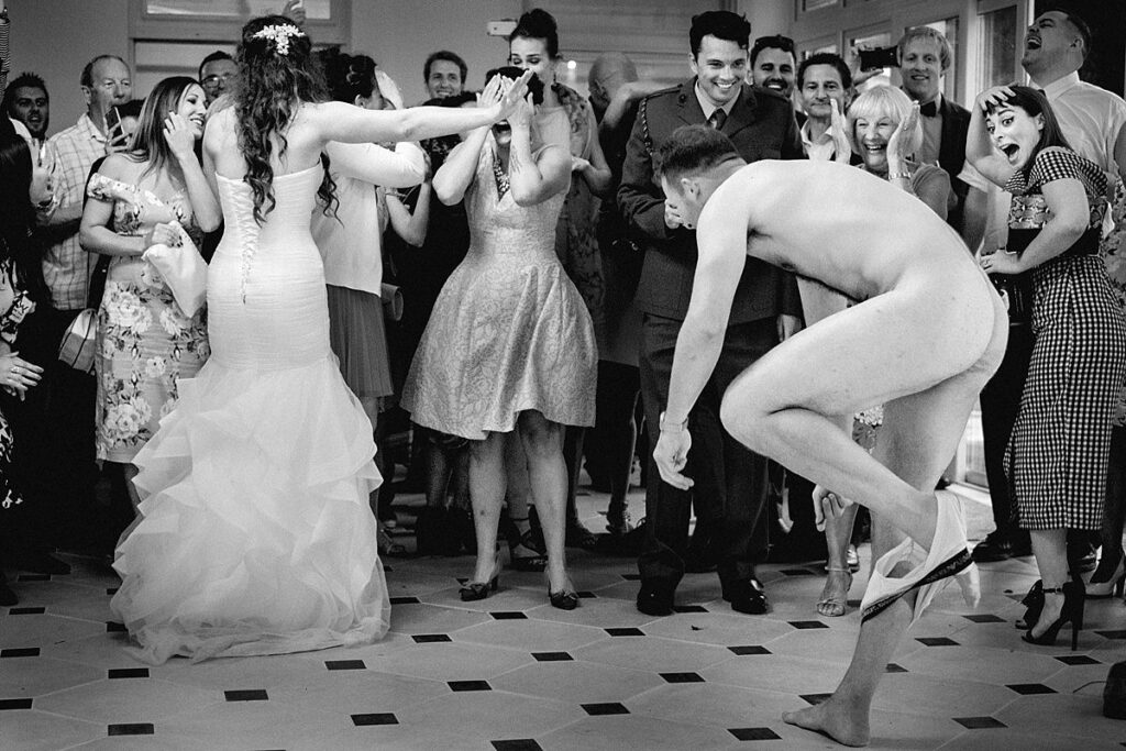 Black and white: a guest leaping naked across the dance floor as the bride and guests react